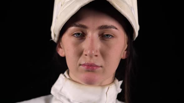 Portrait of a Confident Fencer Looking at the Camera and Putting on a Protective Mask