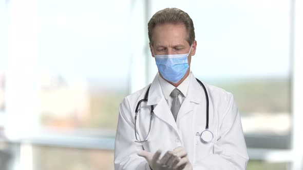 Friendly Doctor Putting on Sterile Gloves