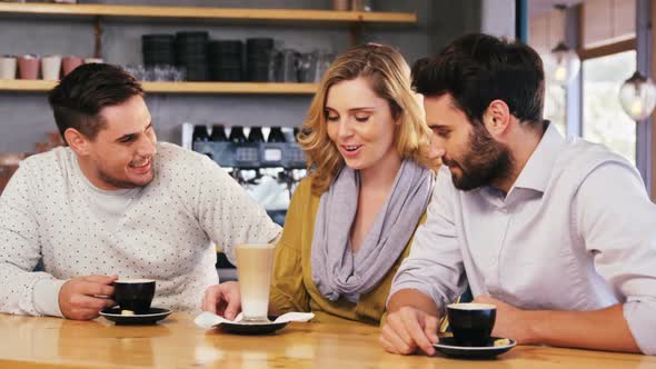 Friends interacting while have a cup of coffee