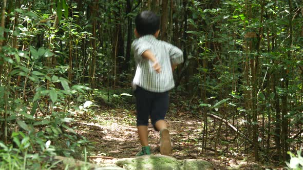 Boy running and playing in forest