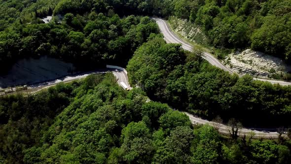 Aerial POV Truck at Mountain Road Going Through Forest Landscape,