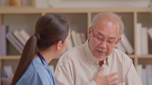 Senior elder man patient talking to caring female doctor physician at nursing home in hospital . Asa