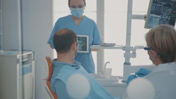 Dentistry Assistant Holding Digital Tablet with Teeth x Ray Scan