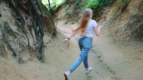 Back View of Pretty Blonde Woman Having Fun in Natural Loess Ravine