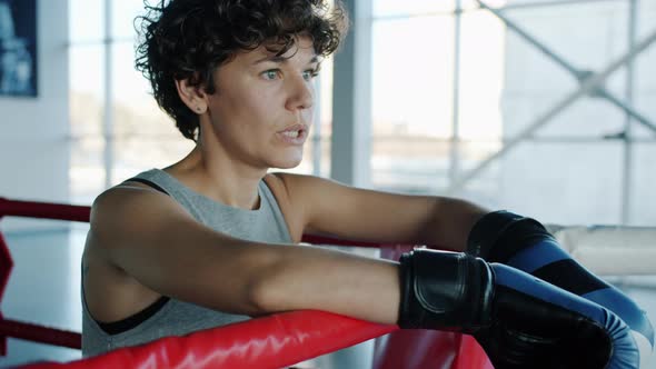 MMA Fighter Pretty Girl Breathing Hard Resting in Ring Corner in Gym