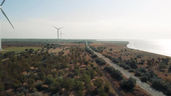 Wind Energy Generators Against Blue Sky, Sea and Fields