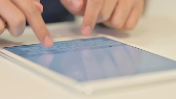 Close Up of Male Hands Typing on Tablet