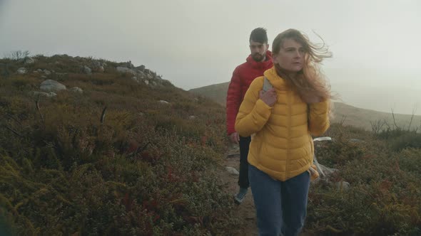 Couple Walk on Dramatic Hike at Sunrise in Field