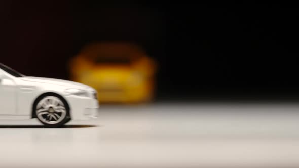 Yellow and white toy cars move on a street