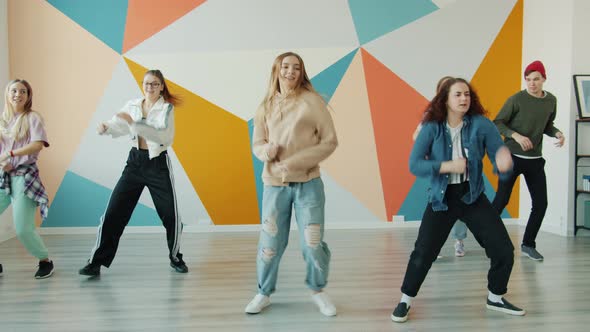 Active Young People Dancing in Modern Hip-hop Class Moving Arms and Legs Having Fun