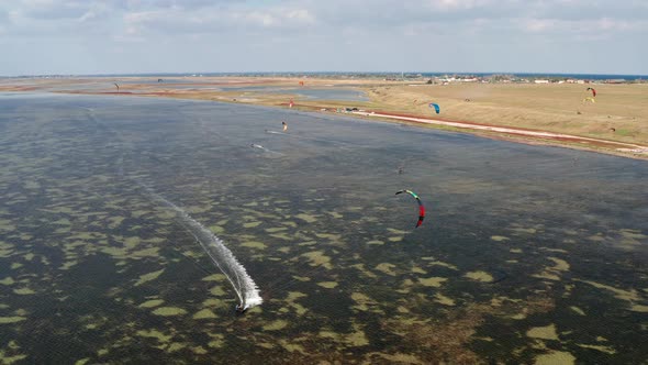 People go kitesurfing on the sea. The wind carries the athlete along the sea waves.