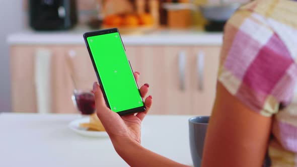 Woman Looking at Phone with Green Touchscreen