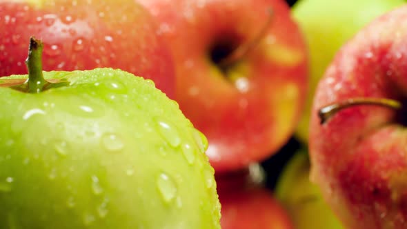 Macro Video of Camera Moving Between Fresh Ripe Green Nad Red Apples Covered with Water Droplets or