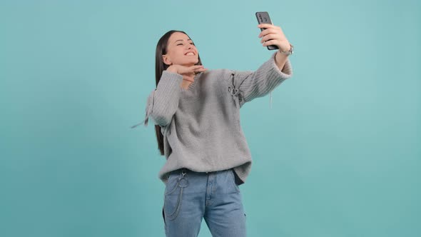 Funny Young Black Haired Woman Taking Selfie on Red Background
