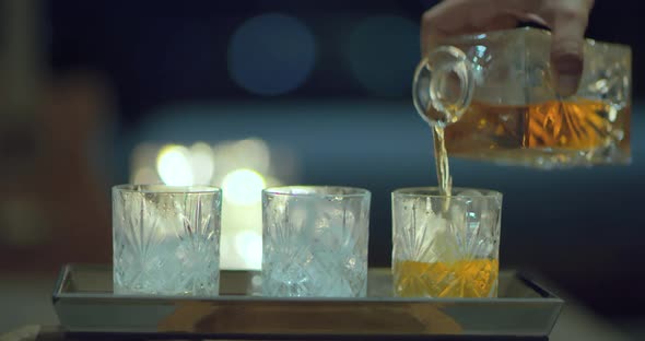 Close Up Shot of the Hand Pouring Whiskey Into the Glasses