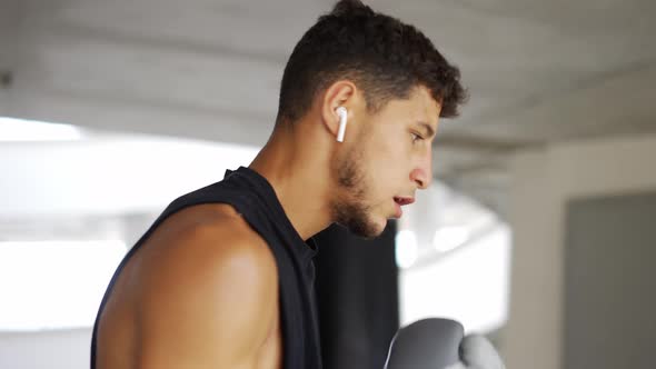 The Man Training with Boxing Bag at the Parking Zone Gym