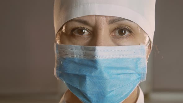 Closeup portrait of an experienced Caucasian female surgeon, doctor with mask ready for work in a ho