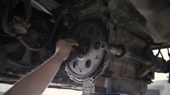 auto car mechanic installs flywheel