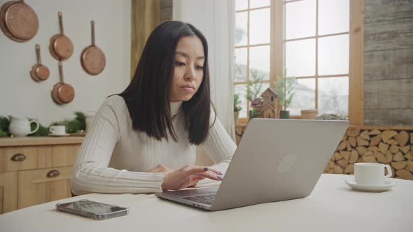 Young Adult Asian Woman is Shopping Online on Her Laptop