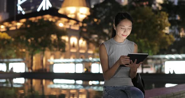 Woman using tablet computer at night