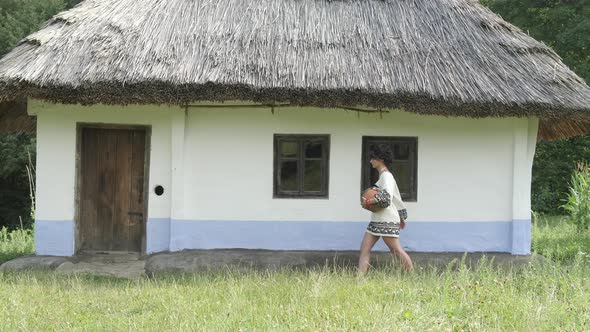 Woman walking by a traditional house alt