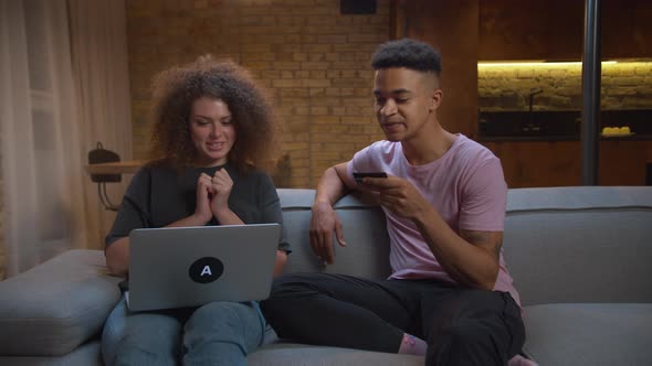 Young Mixed Race Married Couple Making Online Purchase Online Shopping From Home and Giving High