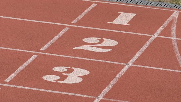 Close-Up View of Empty Running Track With White Lines and Numbers, Stadium