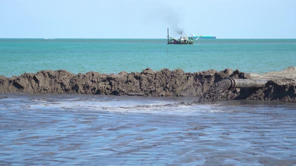 A Boat Does Sand Dredging on the Beach