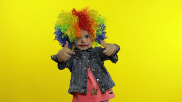 Little Child Girl Clown in Colorful Wig Making Silly Faces. Having Fun, Smiling, Dancing. Halloween
