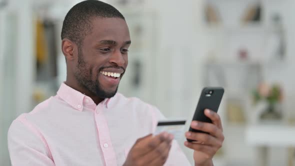 Portrait of African Man Making Successful Online Payment on Smartphone