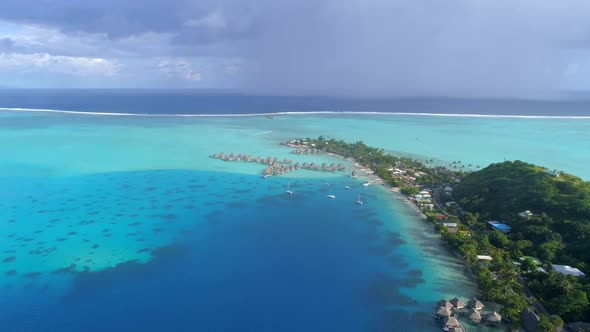 Aerial drone view of a luxury resort and overwater bungalows in Bora Bora tropical island