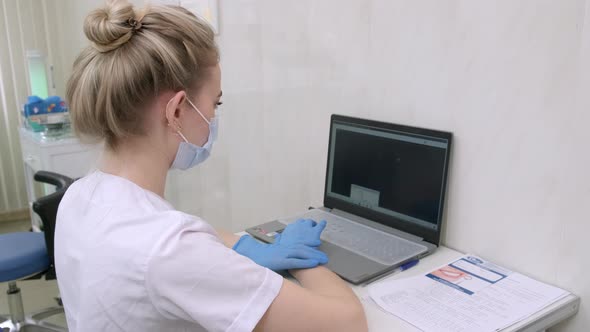 Dentist Assistant Working on Laptop Computer in Dental Clinic