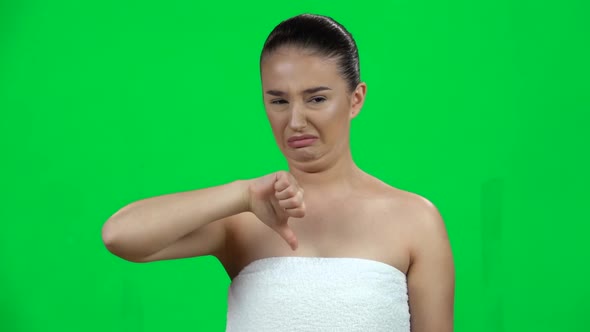 Unhappy Young Girl Showing Thumbs Down Gesture, Isolated on Green Screen at Studio