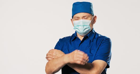 Mature Experienced Surgeon Prepared for Surgery Dressed in Blue Uniform with a Handkerchief on His