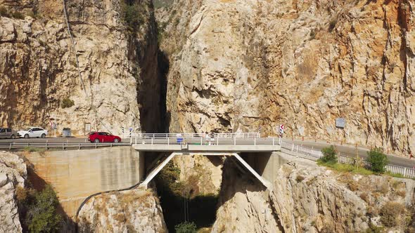 }Young Couple Stands on the Bridge Among the Rocks and Kaputas Beach in Turkey