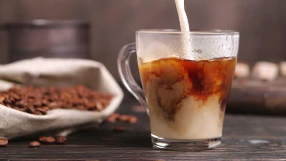 Milk Pouring Into Cup of Coffee