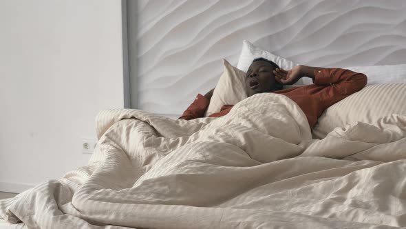 AfricanAmerican Man Awakes and Gets Out of Bed in Morning