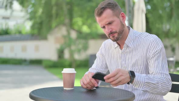 Middle Aged Man Feeling Angry While Waiting in Outdoor Cafe