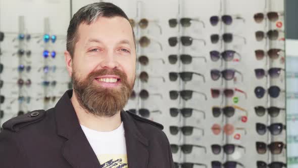 Cheerful Mature Man Smiling To the Camera While Buying Sunglasses