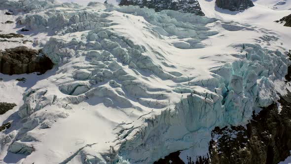 Slow aerial shot of snow covered mountain glacier, outdoor during summer