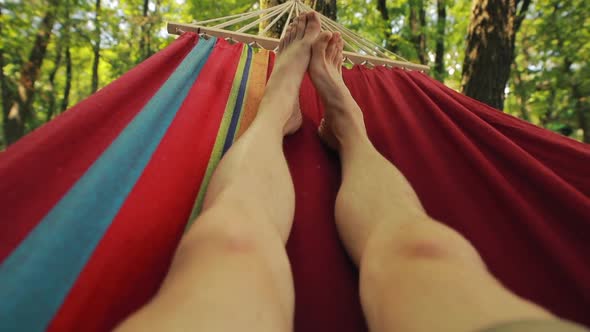 Male Legs Relaxing Lying on Hammock