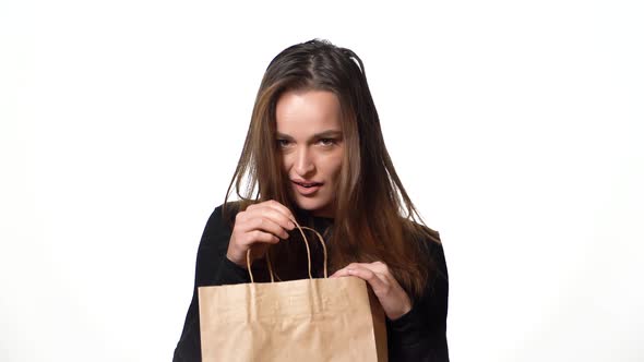 beautiful woman in a black sweater looks mysteriously in a paper packbag