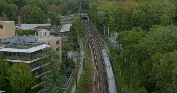 Train Passing Near Buildings and Park in the Village of Great Neck