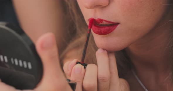 Close Up Slowmotion Footage of How a Girl with a Burgundy Pencil for Makeup Outlines the Contour of