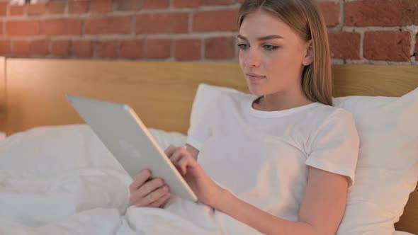 Young Woman Using Tablet in Bed