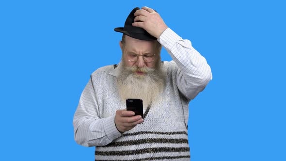 Old Bearded Man Surfing Internet on Mobile Phone