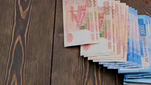 Stack of Russian Rubles Banknotes Dropping on Wooden Surface and Sliding