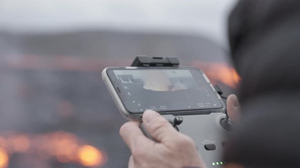 Drone Control Held By Photographer With Screen Showing Lava