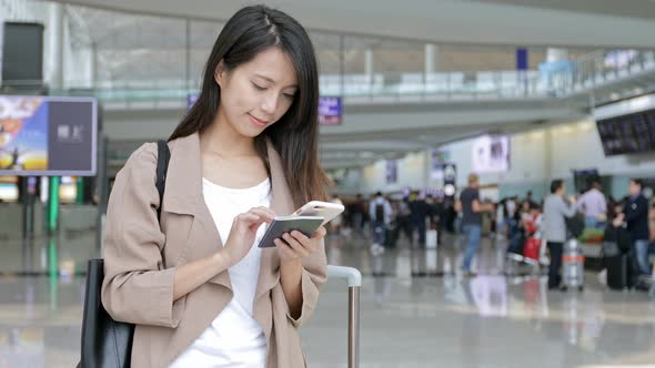 Woman using mobile phone in Hong Kong international airport