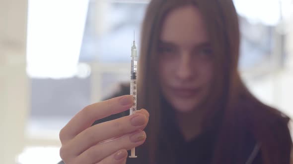 Young Woman Holding the Syringe with the Drug